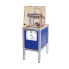 The Shear and Compression Test Apparatus is a compact industrial machine with a blue panel, control buttons, and a transparent safety cover over the testing area, supported by four metal legs against a plain white background.