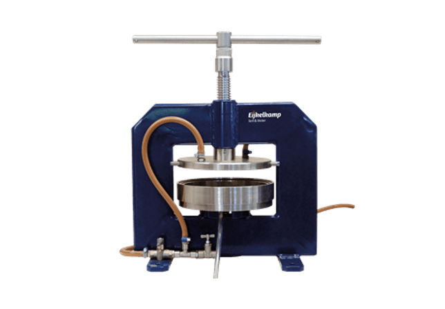 The Membrane Apparatus for PF Determination (PF 3.0-4.2) features a blue hydraulic press with a T-shaped handle, circular metal plates, and an attached brown hose, designed for pressing materials.