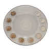The Sand Ruler is a round plastic tray with ten small compartments, each holding a unique sand or soil sample, arranged in a circle on a white background.