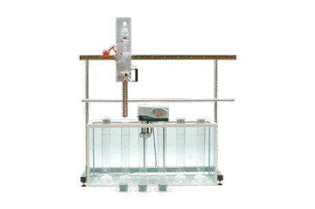 A Pipette Apparatus is set up in a laboratory with a water tank, vertical rods, and multiple containers in front of the tank, all against a plain white background.