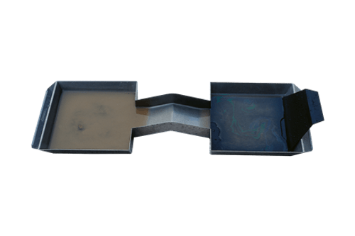 The Oil Detection Pan is a rectangular metal tray with two sections linked by a narrow channel—one side holds murky water for testing, whilst the other remains empty and clean.