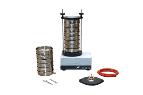 The Granular Composition Test Set for Wet and Dry Sieving features a laboratory sieve shaker with stacked metal sieves, extra sieves, spanners, a red hose, and a black component arranged on a white background.