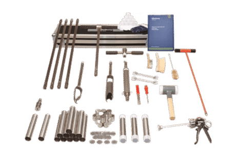 The Soil Coring Kit - Chemical Research is displayed on a white surface, featuring metal rods, sampling tubes, a mallet, spanners, a manual, and assorted tools neatly arranged in rows.